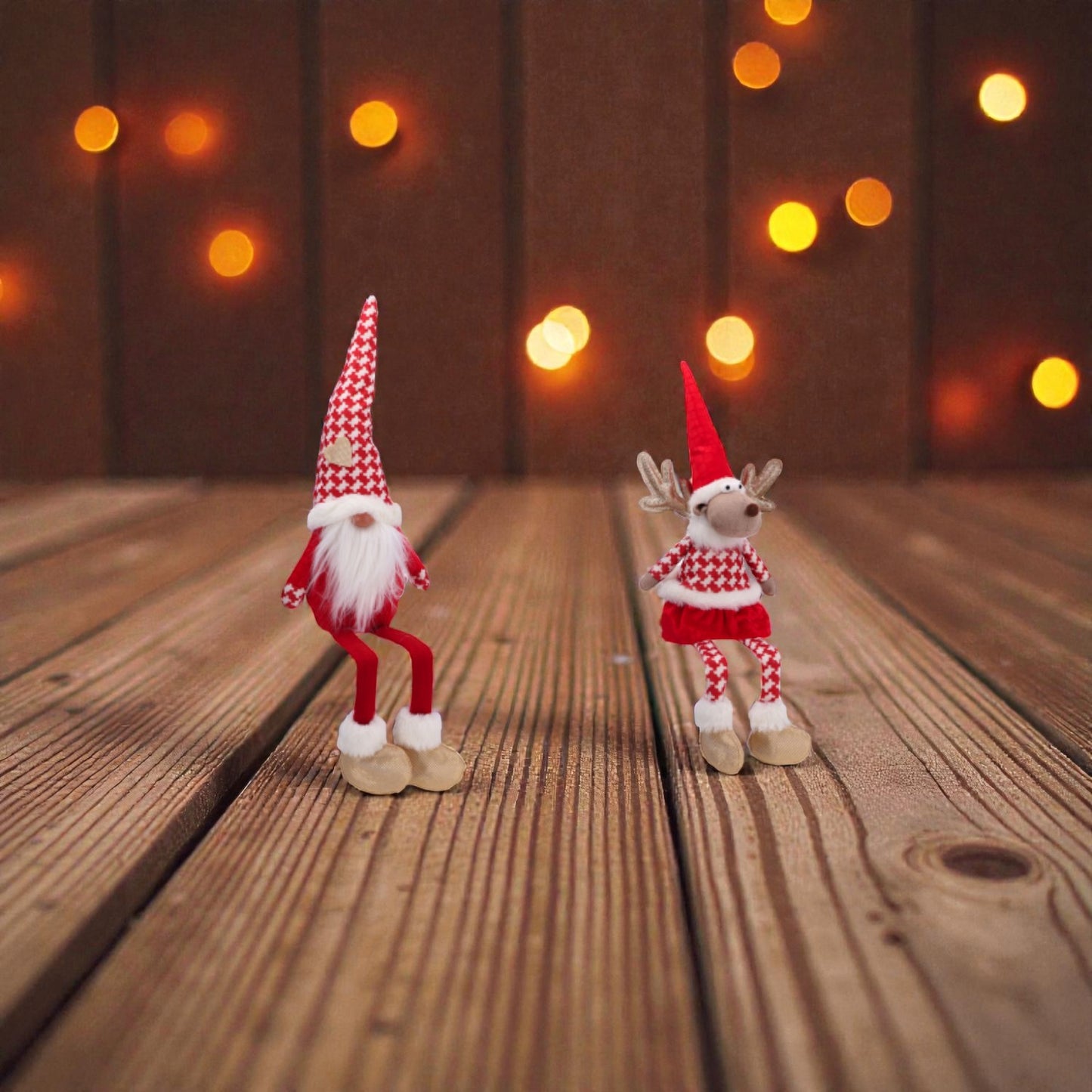 Uno gnomo e una renna in tessuto con abiti natalizi su un piano in legno a Natale.