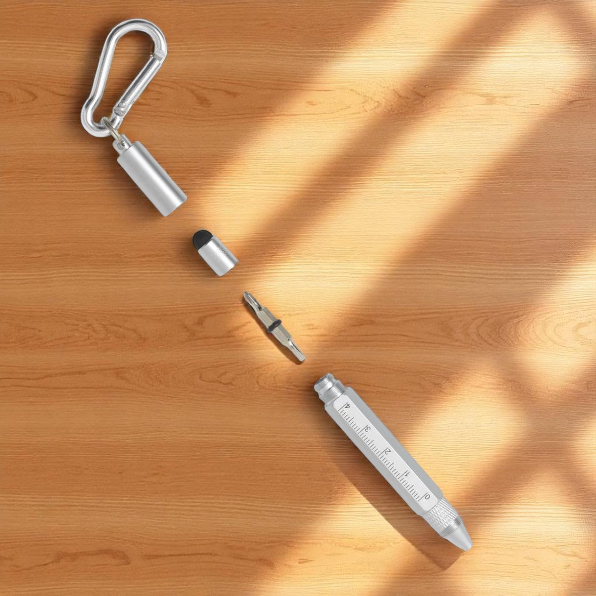 Visione esplosa di una penna in metallo multifunzione con righello, punta touchscreen, moschettone, e doppia punta di cacciavite. Prodotto di Legami, venduto da Prodomo.