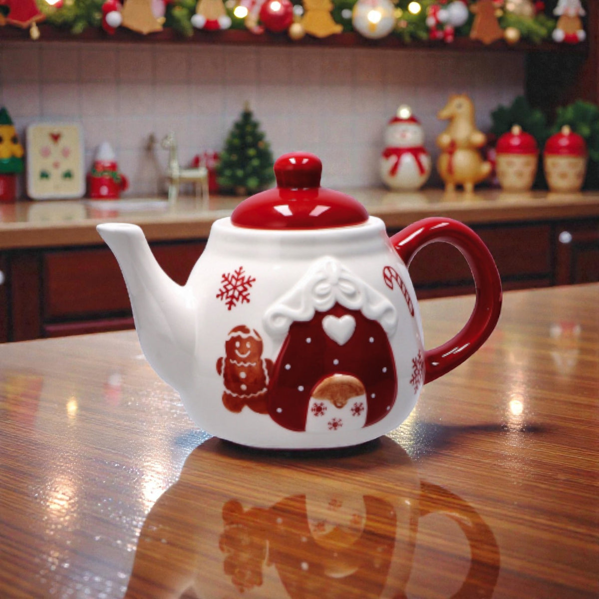 Teiera di natale in ceramica rossa e bianca con illustrazione omino e casa di marzapane, ambienta su un piano in legno in una casa festiva.