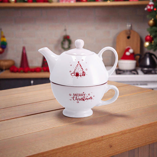 Combo tazza e teiera corby bianca che si possono impilare, con illustrazione a tema natalizio, ambientate su un piano in legno in una cucina festiva e accogliente.