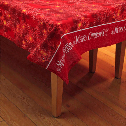 Tovaglia di Natale rossa Melin in tessuto con motivi natalizi, su un tavolo in legno