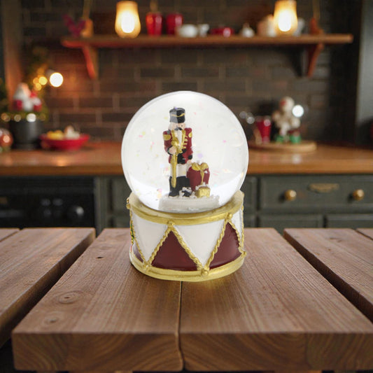 Palla di neve con schiaccianoci e base in resina, ambientata in una casa accogliente.