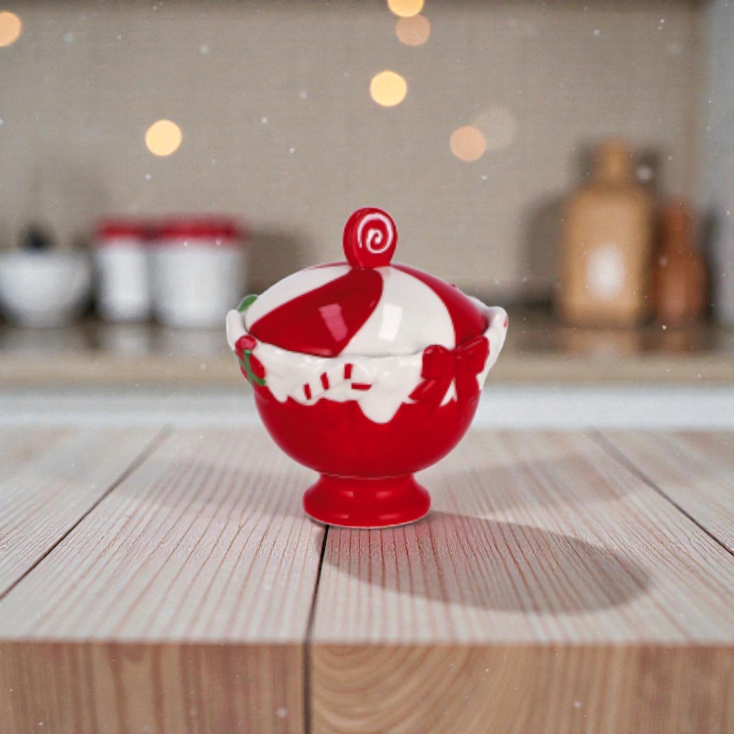 Contenitore in ceramica natalizio a forma di coppetta, colore rosso e bianco, ambientato su un piano in legno con una cucina come sfondo.