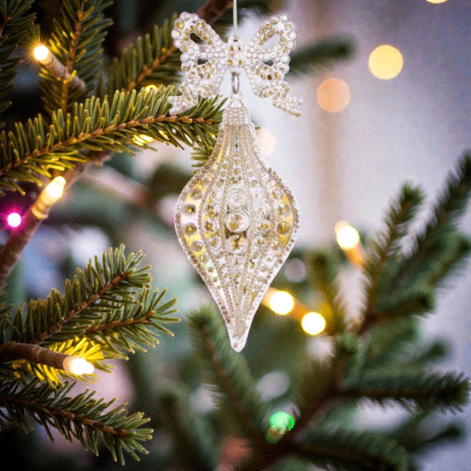 Decorazione albero di natale in acrilico trasperante e dorata, appesa ad un albero di natale.