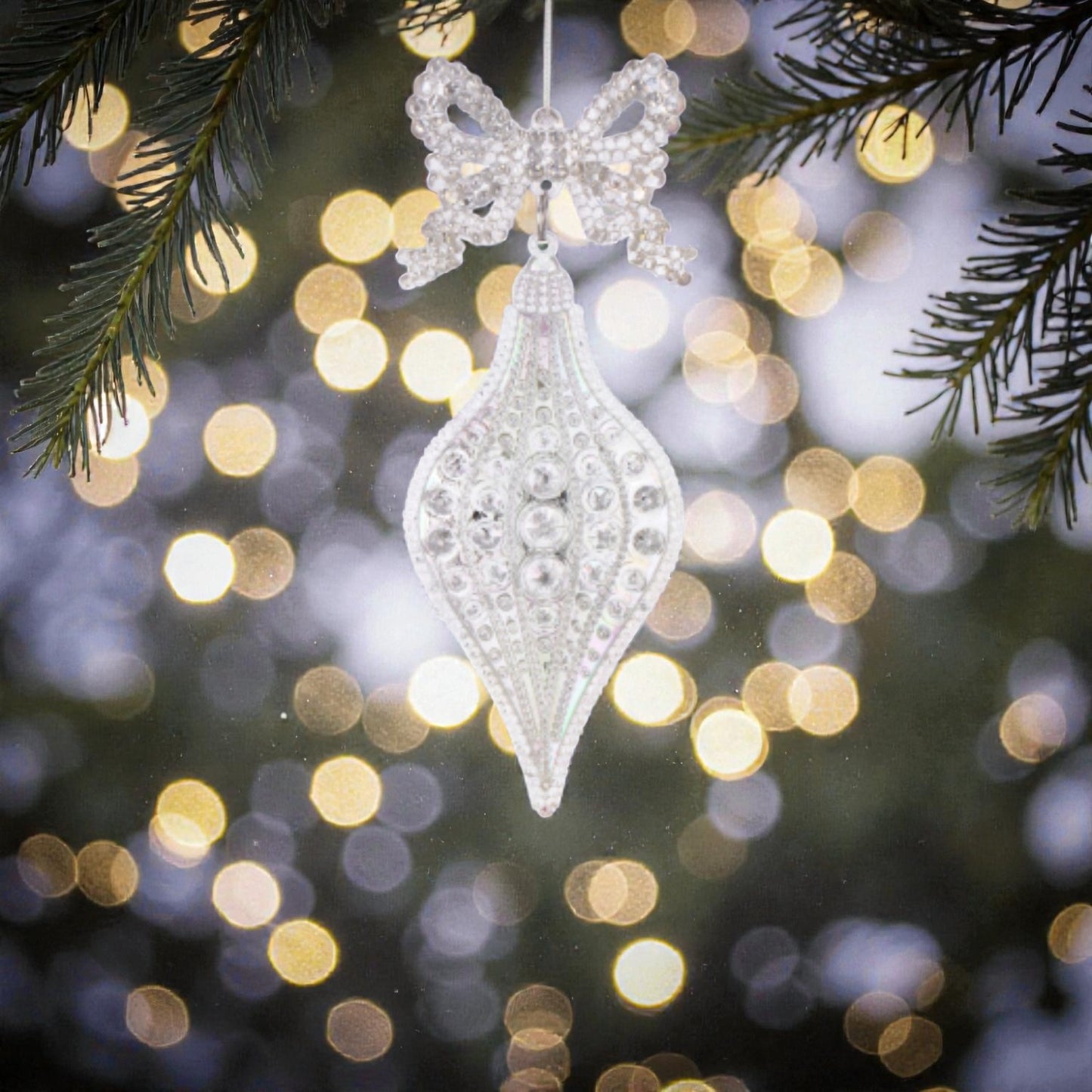 Decorazione albero di natale in acrilico trasperante e bianca, appesa ad un albero di natale.
