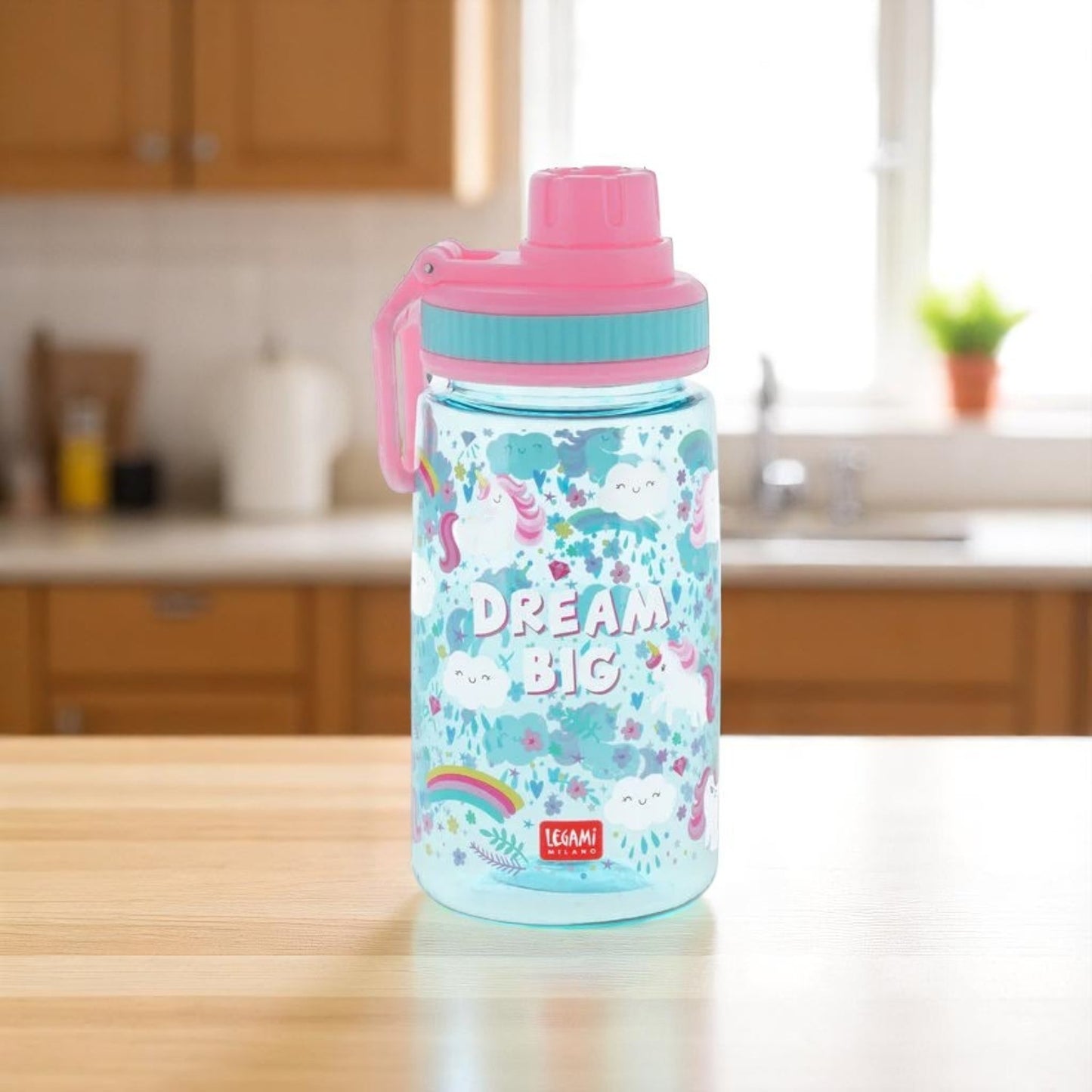Borraccia per bambini rosa a tema unicorno con una cucina come sfondo. 
Borraccia Let's Drink di Legami, venduta da Prodomo o Pro Domo