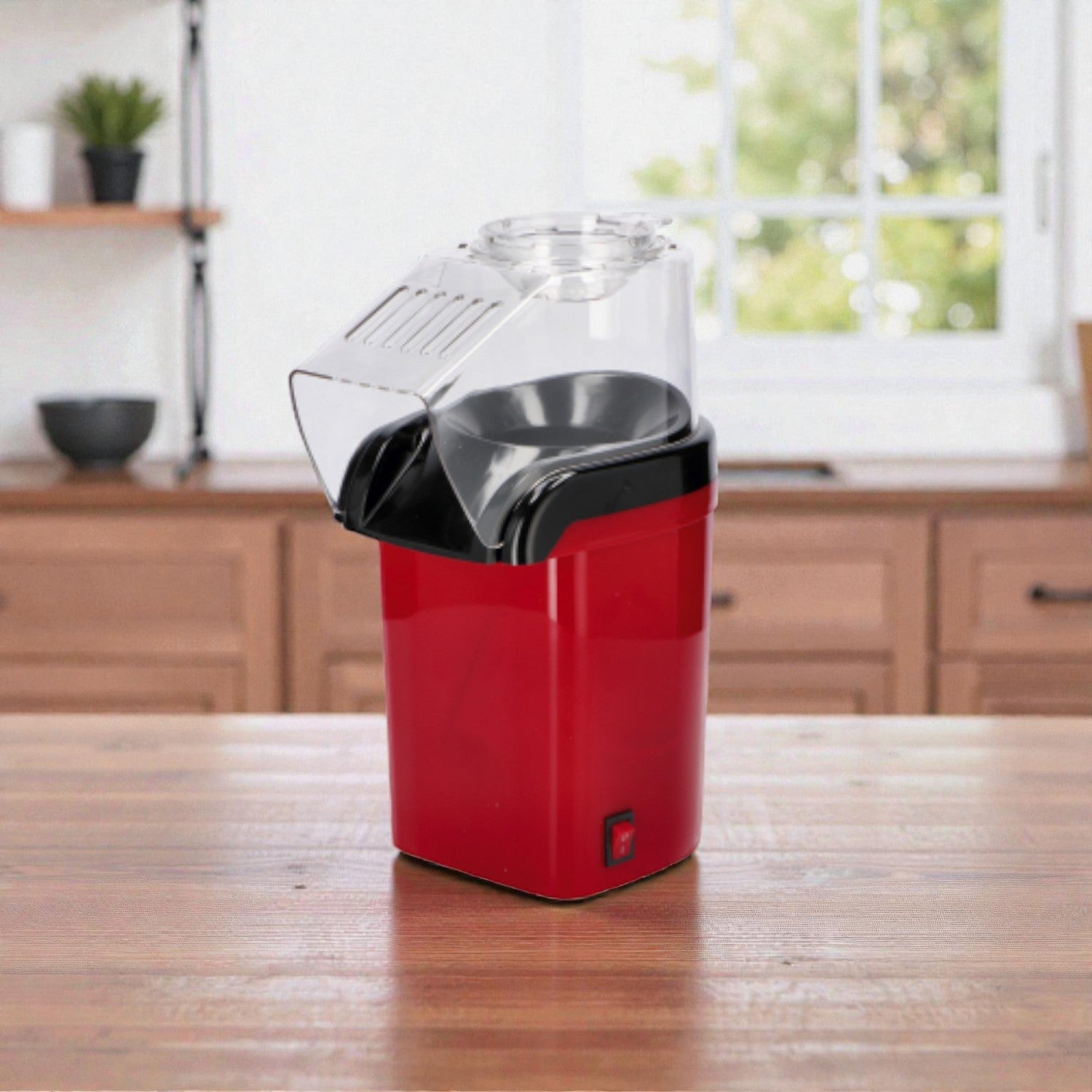 Macchinetta per pop-corn rossa con coperchio trasparente. Ambientata in una casa luminosa