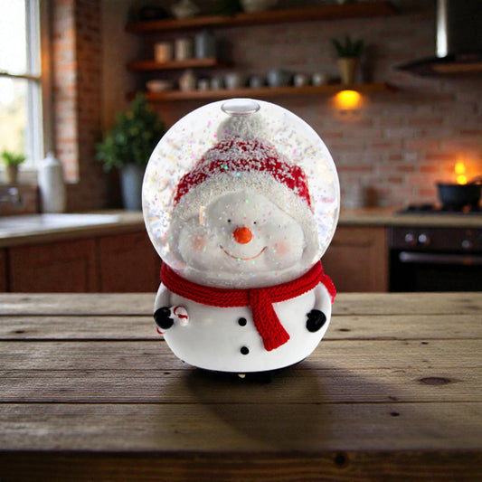 Palla di neve Natalizia a forma di pupazzo di neve con testa dentro la sfera, ambientato in una casa natalizia