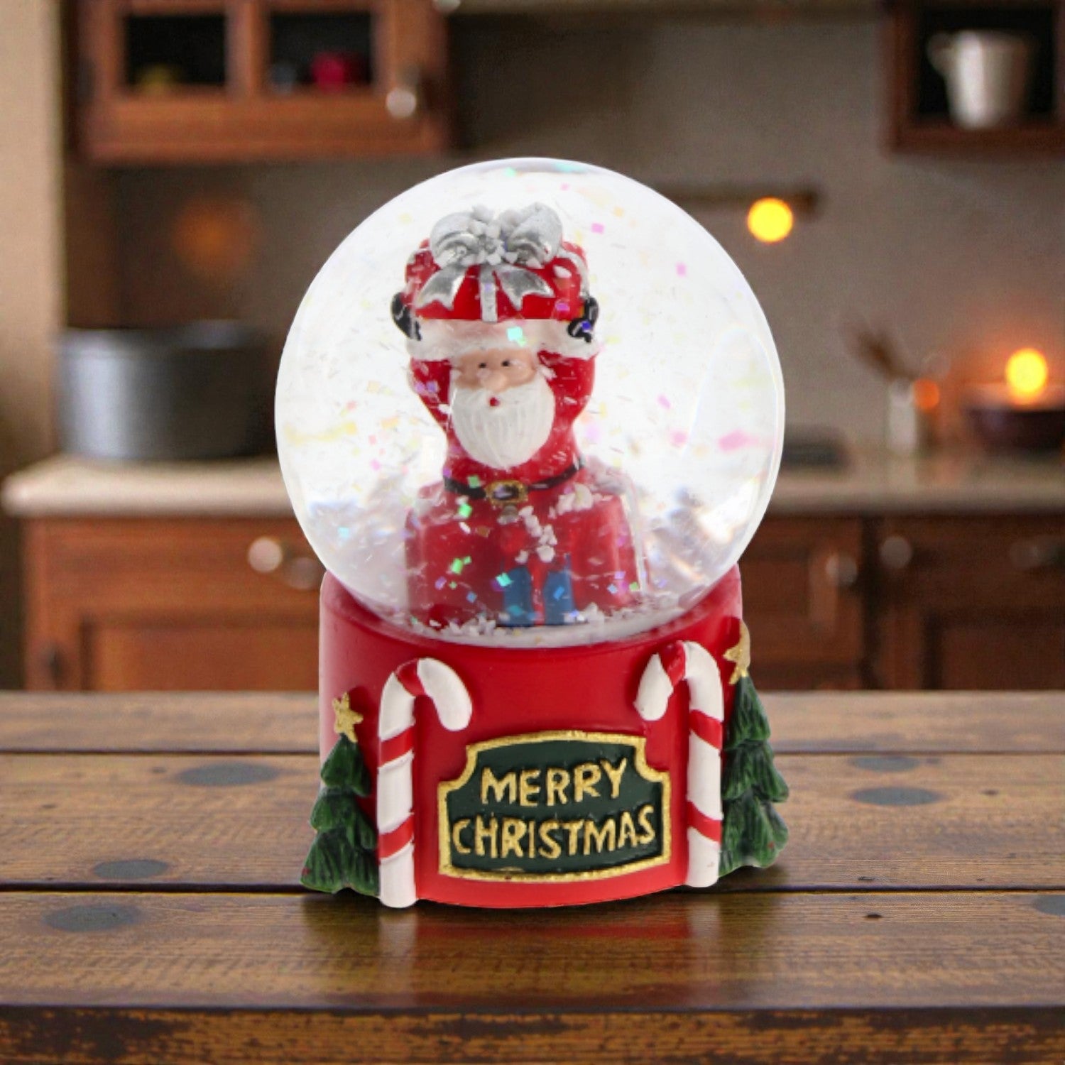 Palla di neve con babbo natale e base in resina, ambientata in una casa accogliente.