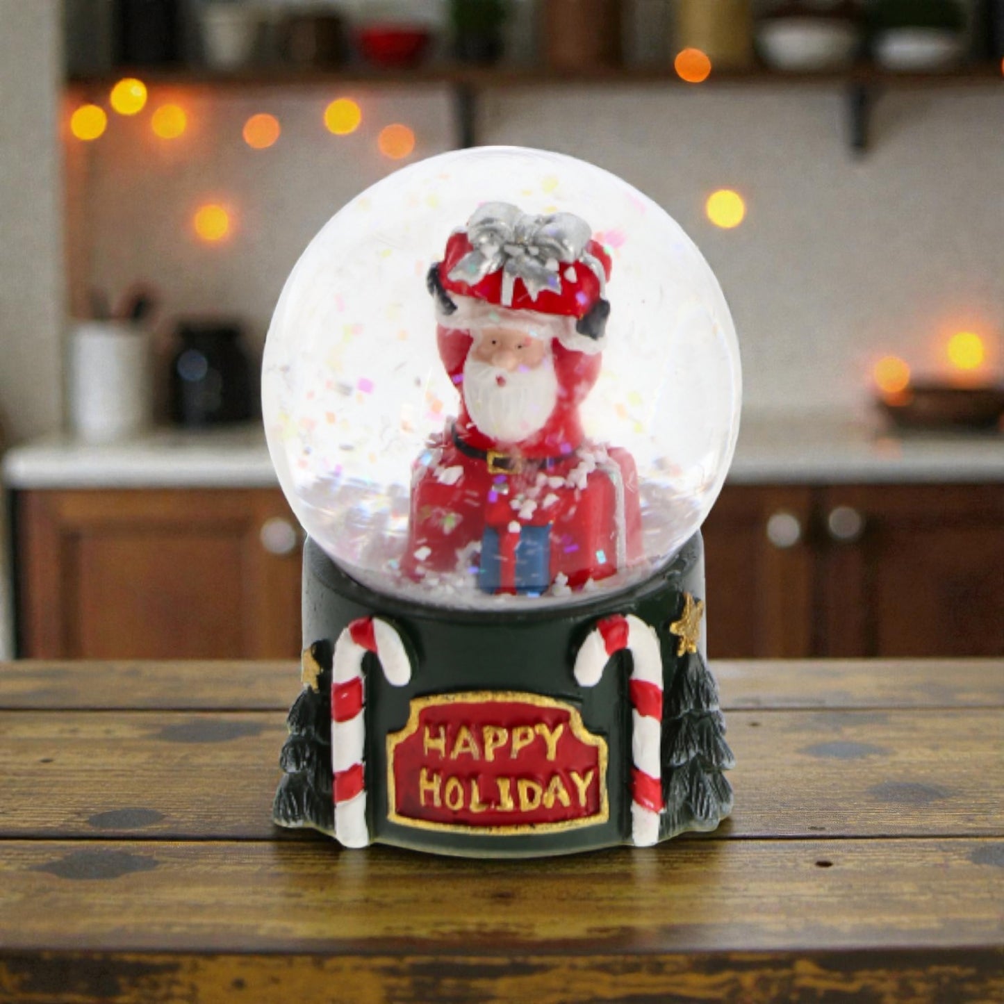 Palla di neve con babbo natale e base in resina, ambientata in una casa accogliente.