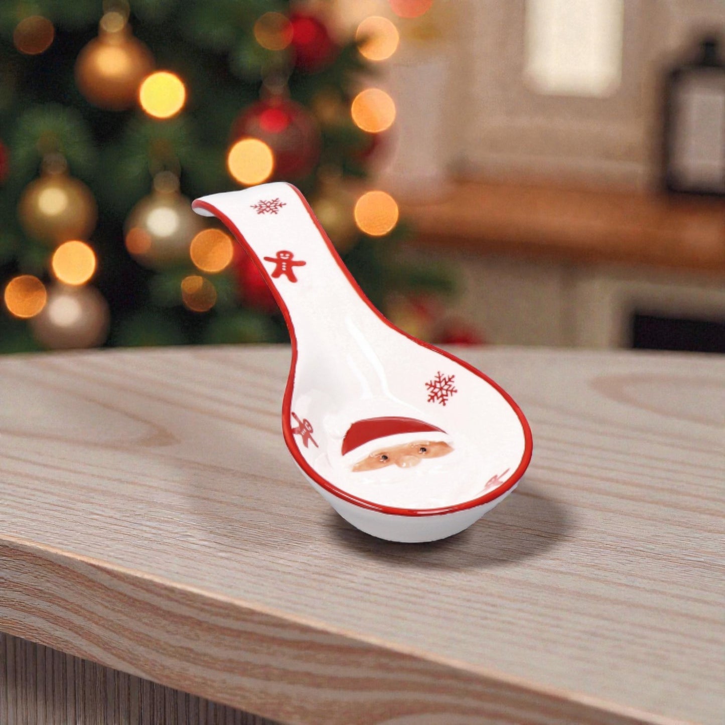 Porta cucchiaio di Natale rosso e Bianco sopra un piano cucina in legno con sfondo natalizio.