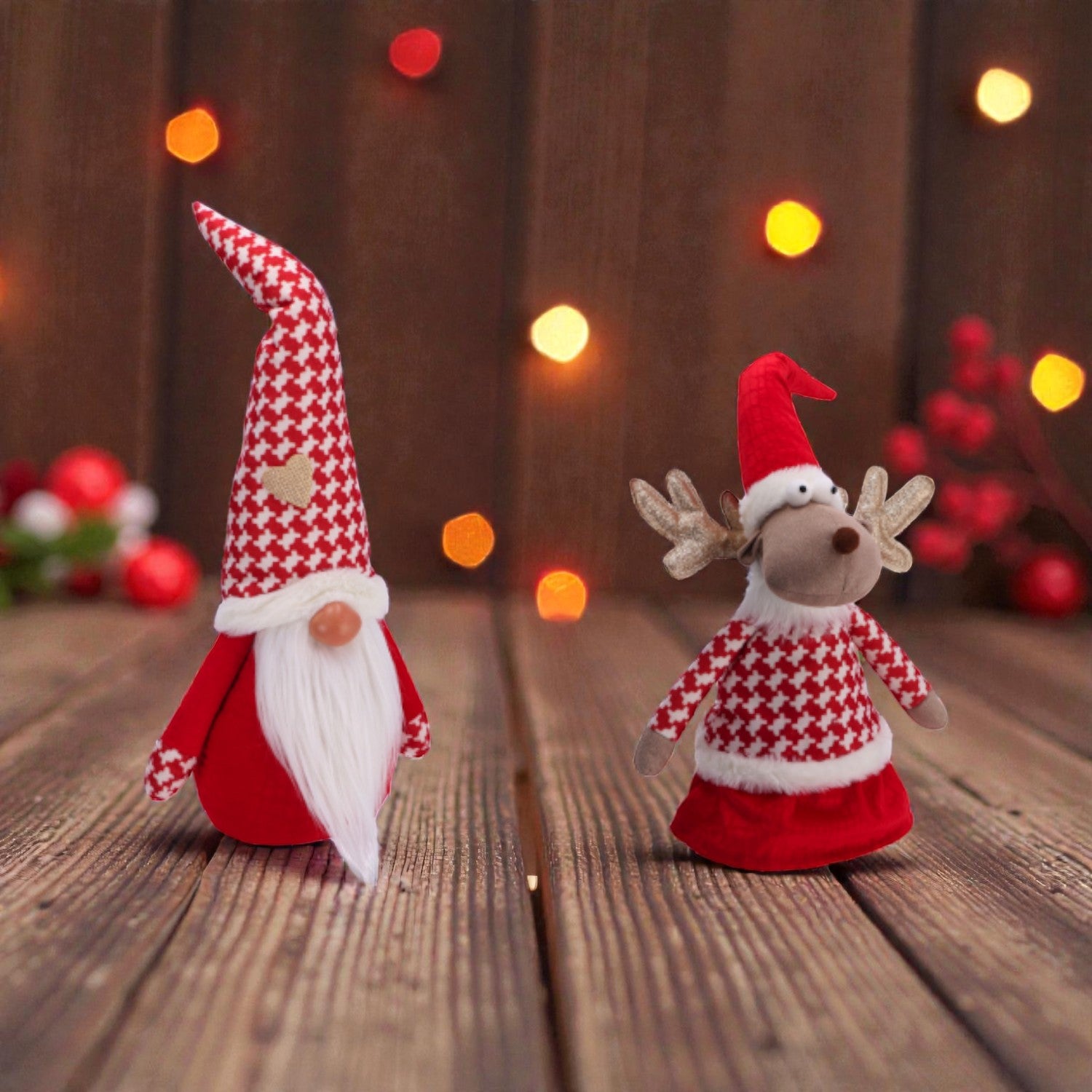 Decorazioni di natale a forma di gnomo e renna con vestiti natalizi, con uno sfondo natalizio su un piano in legno.