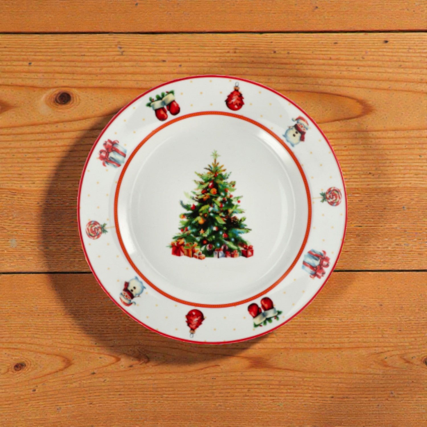 Piatto di natale bianco con righe rosse e verdi con disegno albero di natale su un piano in legno.