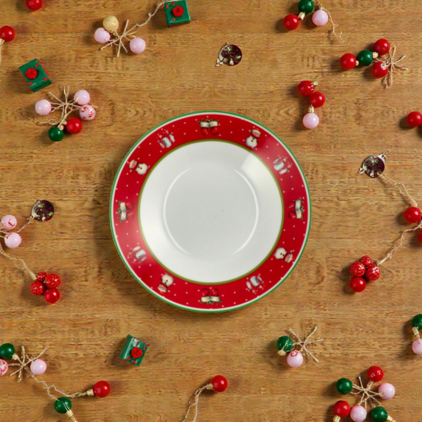 Piatto di natale bianco con righe rosse e verdi con su un piano in legno.