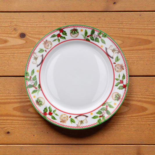 Piatto di natale con rig rossa e verde e disegno di vischio natalizio su un piano in legno.