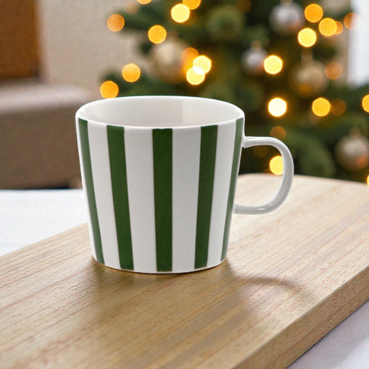 Tazza di natale a righe verticali bianca e verde, in una casa natalizia.