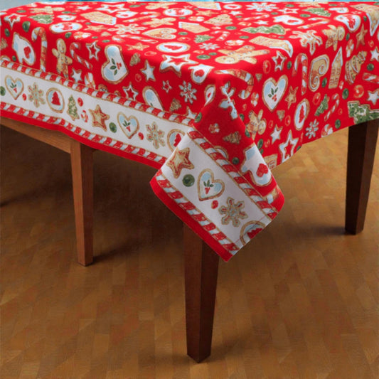 Tovaglia di Natale rossa Melin in tessuto con motivi natalizi, su un tavolo in legno