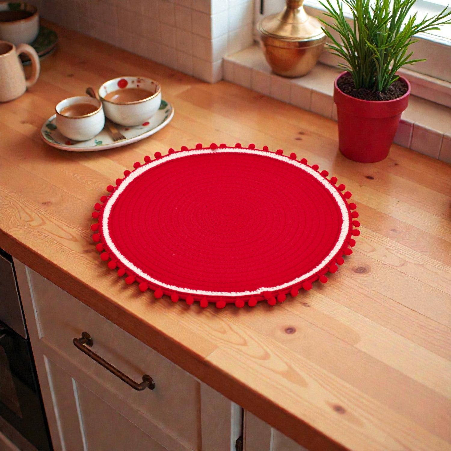 Tovagliette rossa adecorativa, centro tavola natalizio bianco su piano in legno ambientato in una casa natalizia.