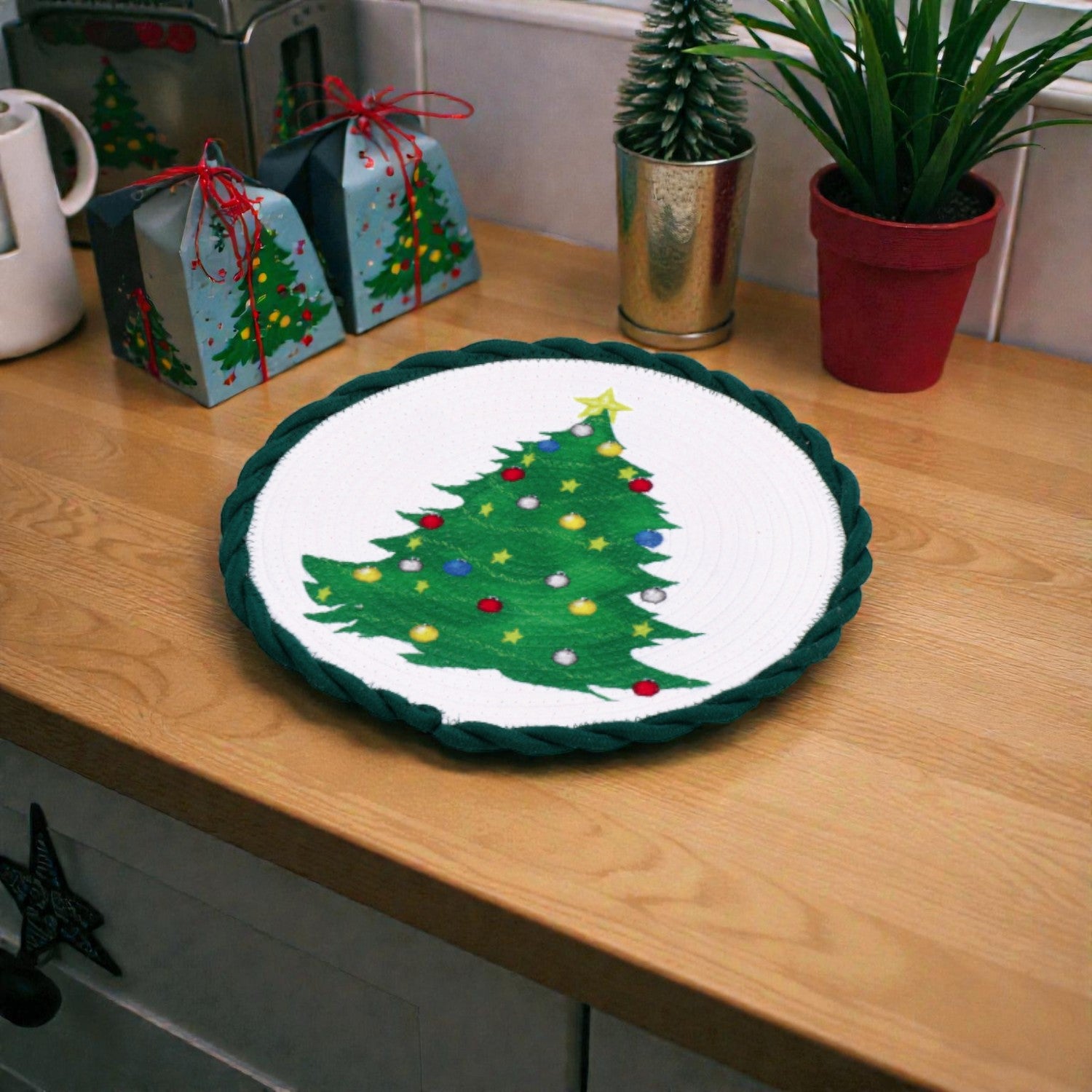 Tovaglietta verde con albero di natale decorativa centro tavola natalizio bianco su piano in legno ambientato in una casa natalizia.