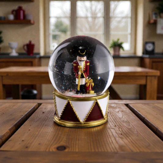 Palla di neve con schiaccianoci con base in resina e luci LED. Ambientata in una casa accogliente.