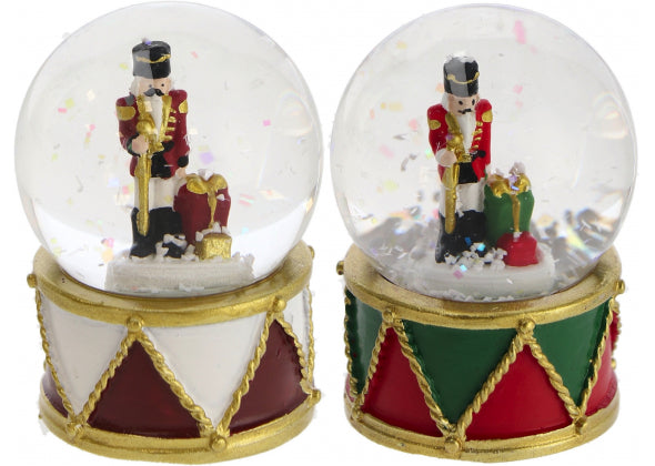 Palla di neve con schiaccianoci e base in resina, con uno sfondo bianco.