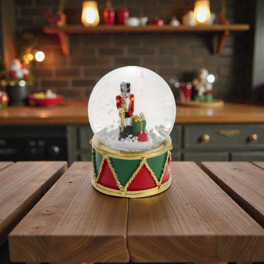 Palla di neve con schiaccianoci e base in resina, ambientata in una casa accogliente.