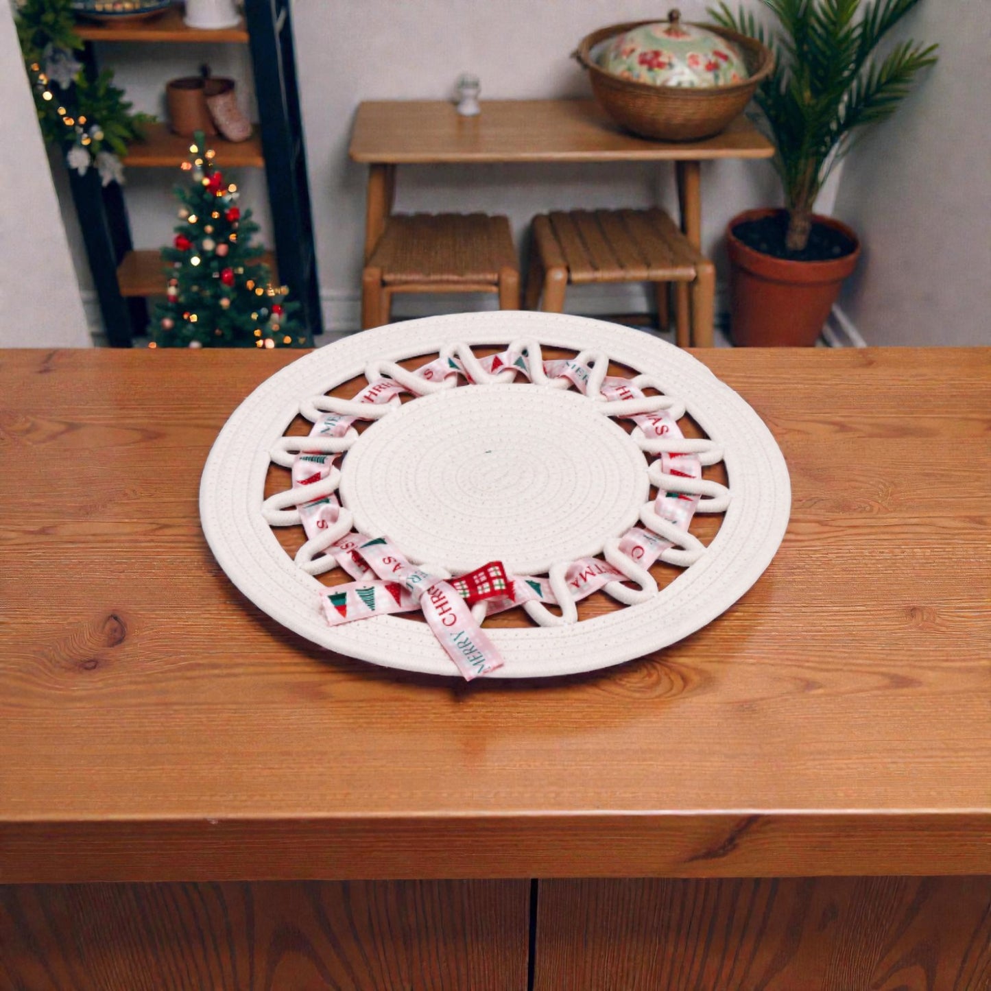 Tovaglietta decorativa centro tavola natalizio bianco su piano in legno ambientato in una casa natalizia.